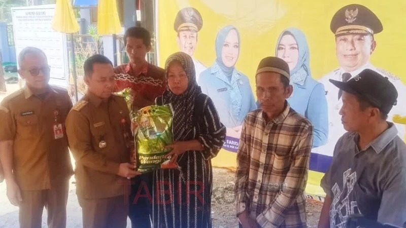 Bupati Tapin, H Yamani didampingi Kadinsos setempat, menyerahkan bantuan sembako pada penyaluran BST, dalam rangka pencanangan Program TPKD (foto: TABIRkota/diskominfo)